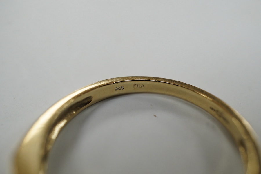 A modern 9ct gold and channel set sapphire and diamond set half hoop ring, size N/O, gross weight 2.2 grams. Condition - fair